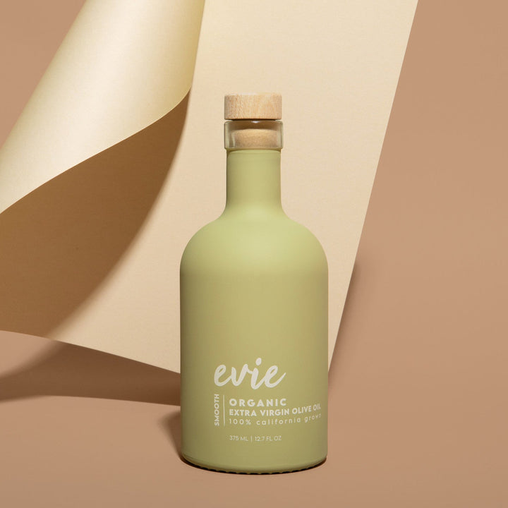 Green bottle labeled 'evie' on a beige background